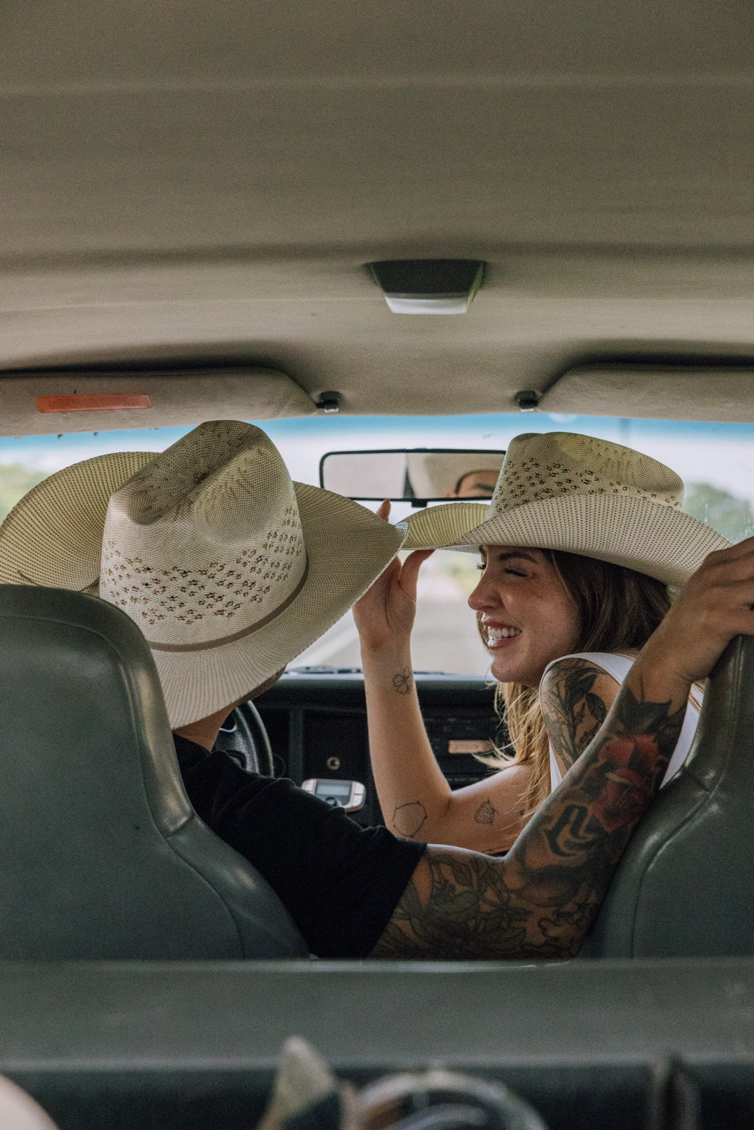 Man and Women in a car wearing Rock'em Cattleman Straw hat