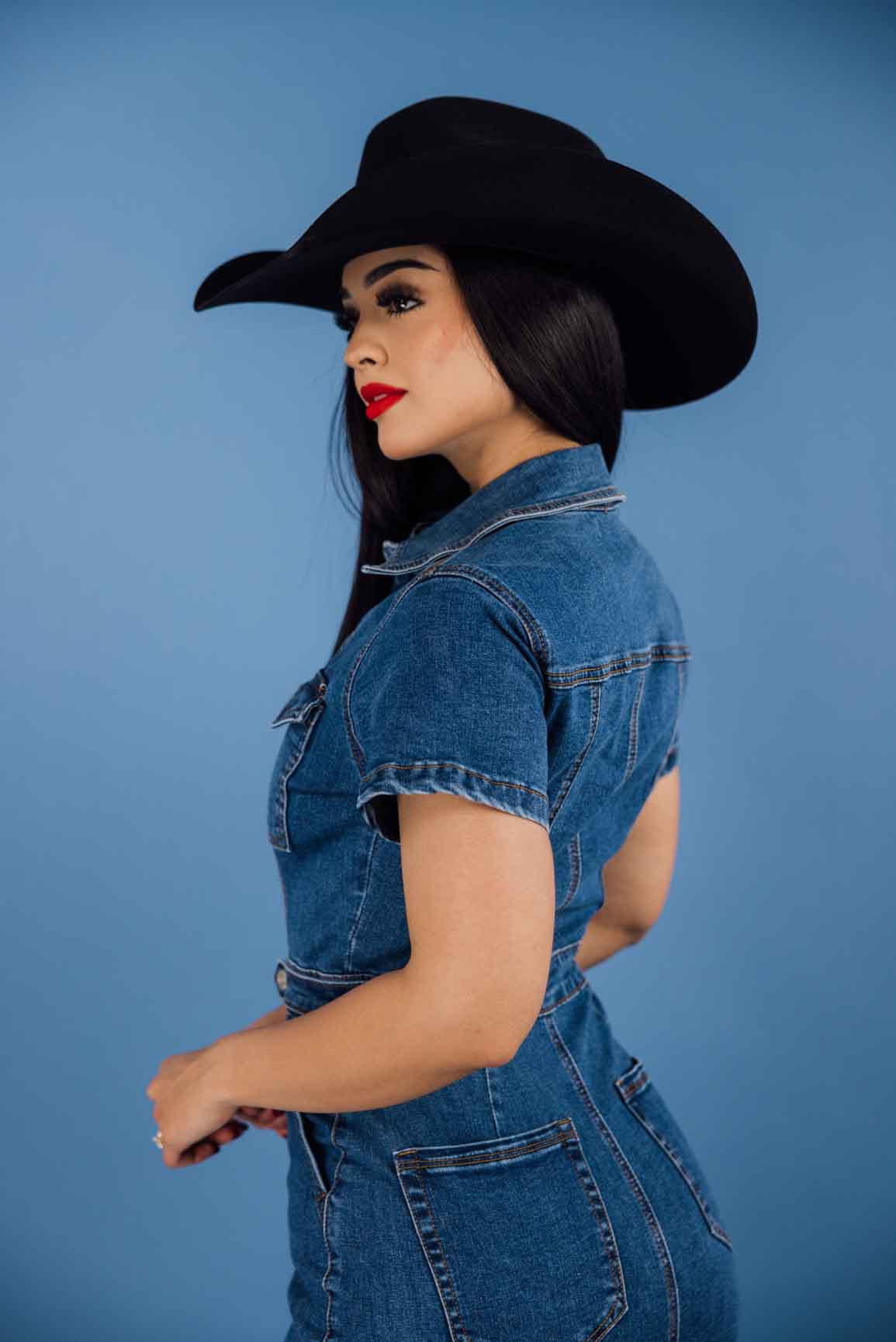 This denim collared short-sleeve button-down mini dress has a relaxed fit with a medium wash, side pockets, and chest pockets.