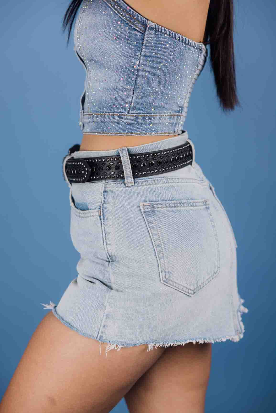 The 90's Vintage mini skirt is made of light-wash denim with frayed edges and a mid-rise fit