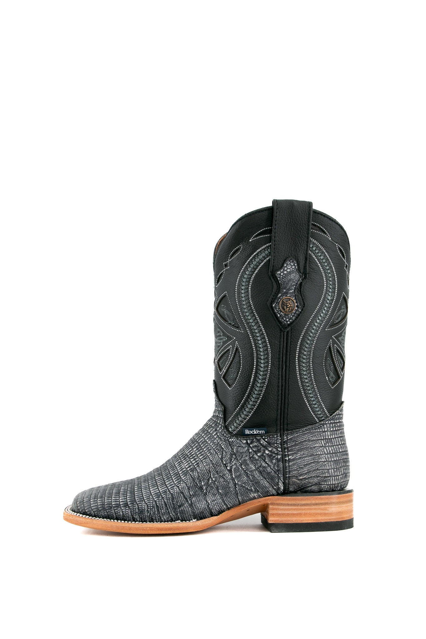 The Lizard Matte cowboy boots feature a square toe, black safari lizard print vamp, smooth black leather shaft with intricate stitching, rubber heel, and Rock'em bull emblem.