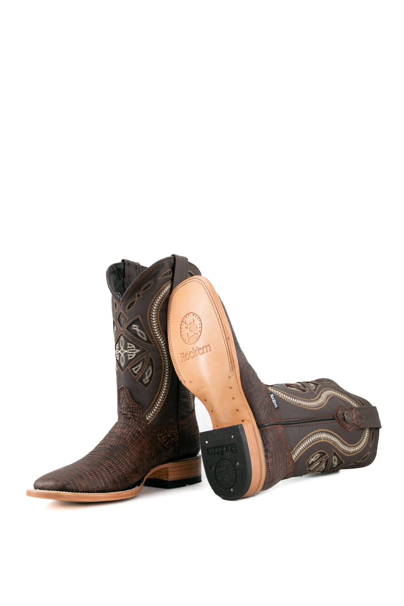 The Lizard Matte cowboy boots feature a square toe, brown lizard print vamp, smooth brown leather shaft with intricate stitching, rubber heel, and Rock'em bull emblem.
