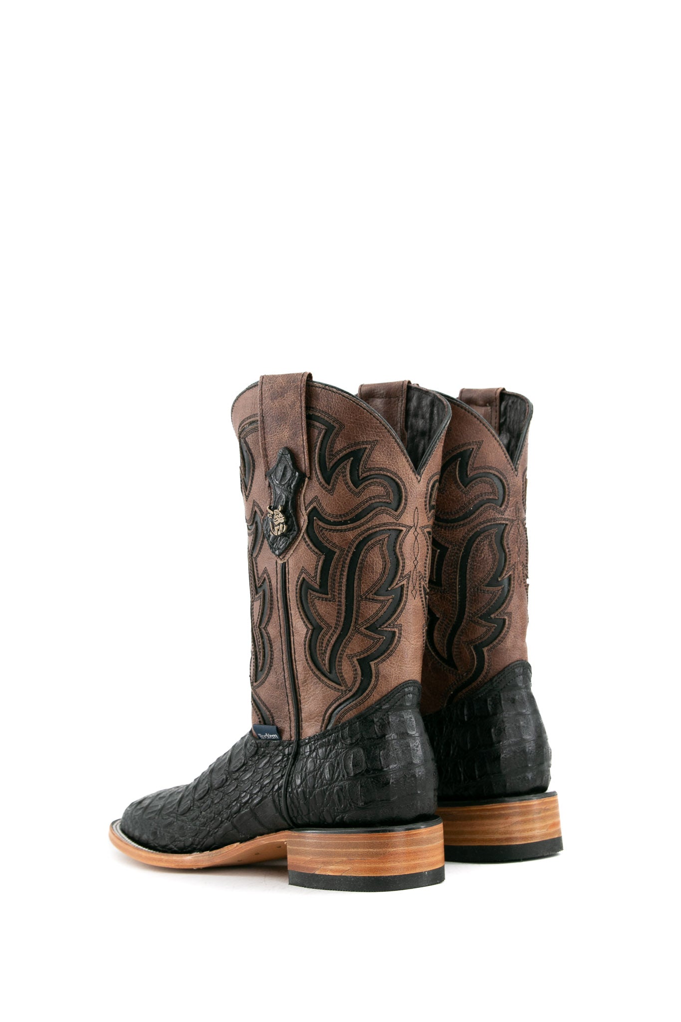 Back view of black Cody Caiman cowboy boots in genuine leather, featuring a square toe, brown shaft with black embroidery, caiman print vamp, and rubber heel.