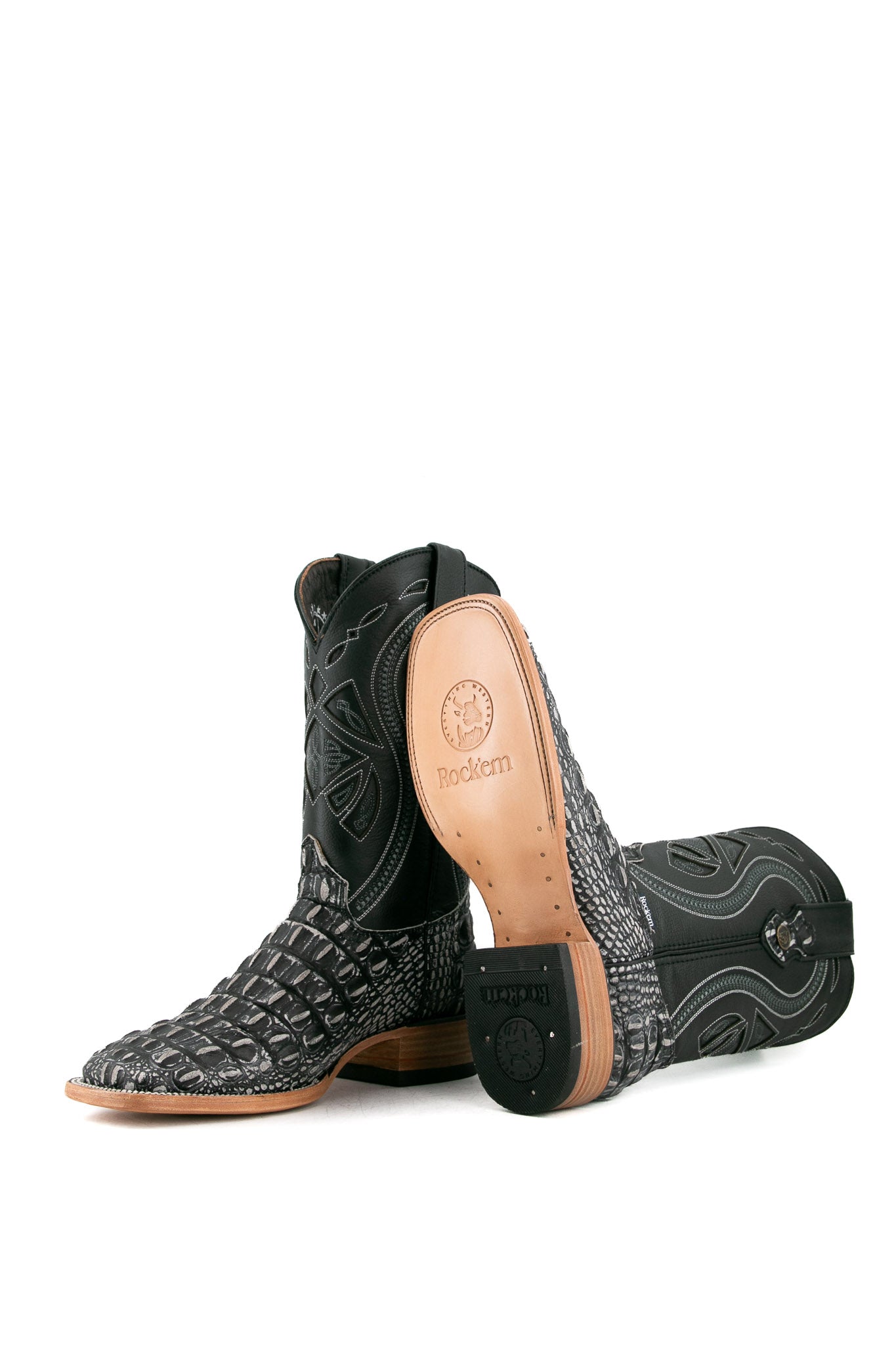 View of black safari Giant Caiman Hornback cowboy boots in genuine leather, featuring a square toe, black and white caiman print vamp, black shaft with white embroidery, tan leather sole, and rubber heel.