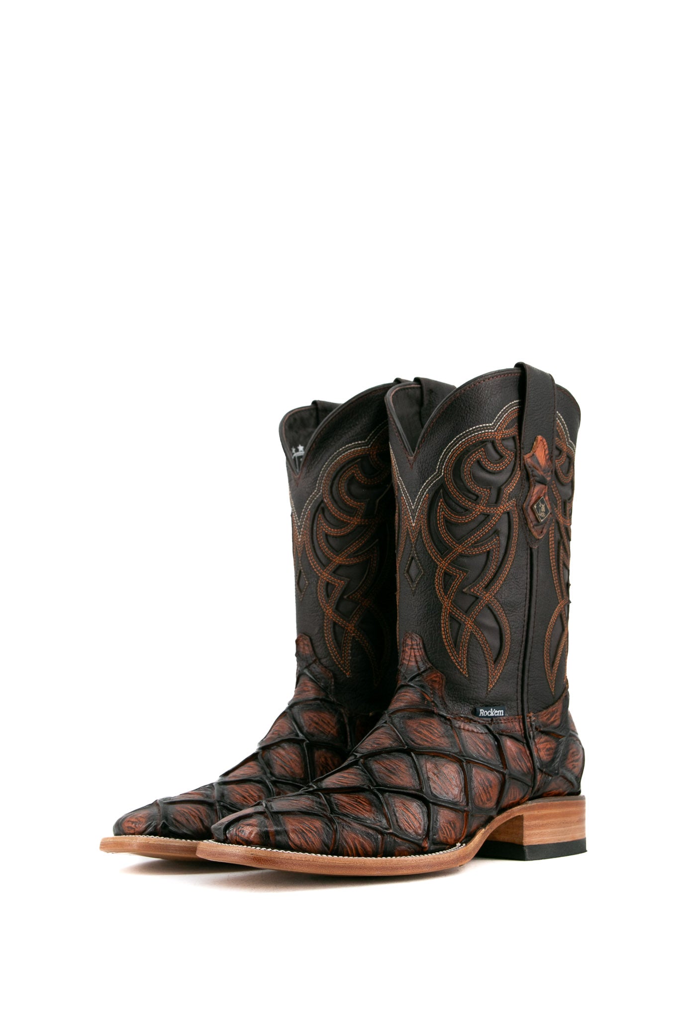 The shedron Big Bass Pirarucu Cowboy Boot features genuine leather, square toe, shedron pirarucu print vamp, brown embroidered shaft, rubber heel, and tan sole.