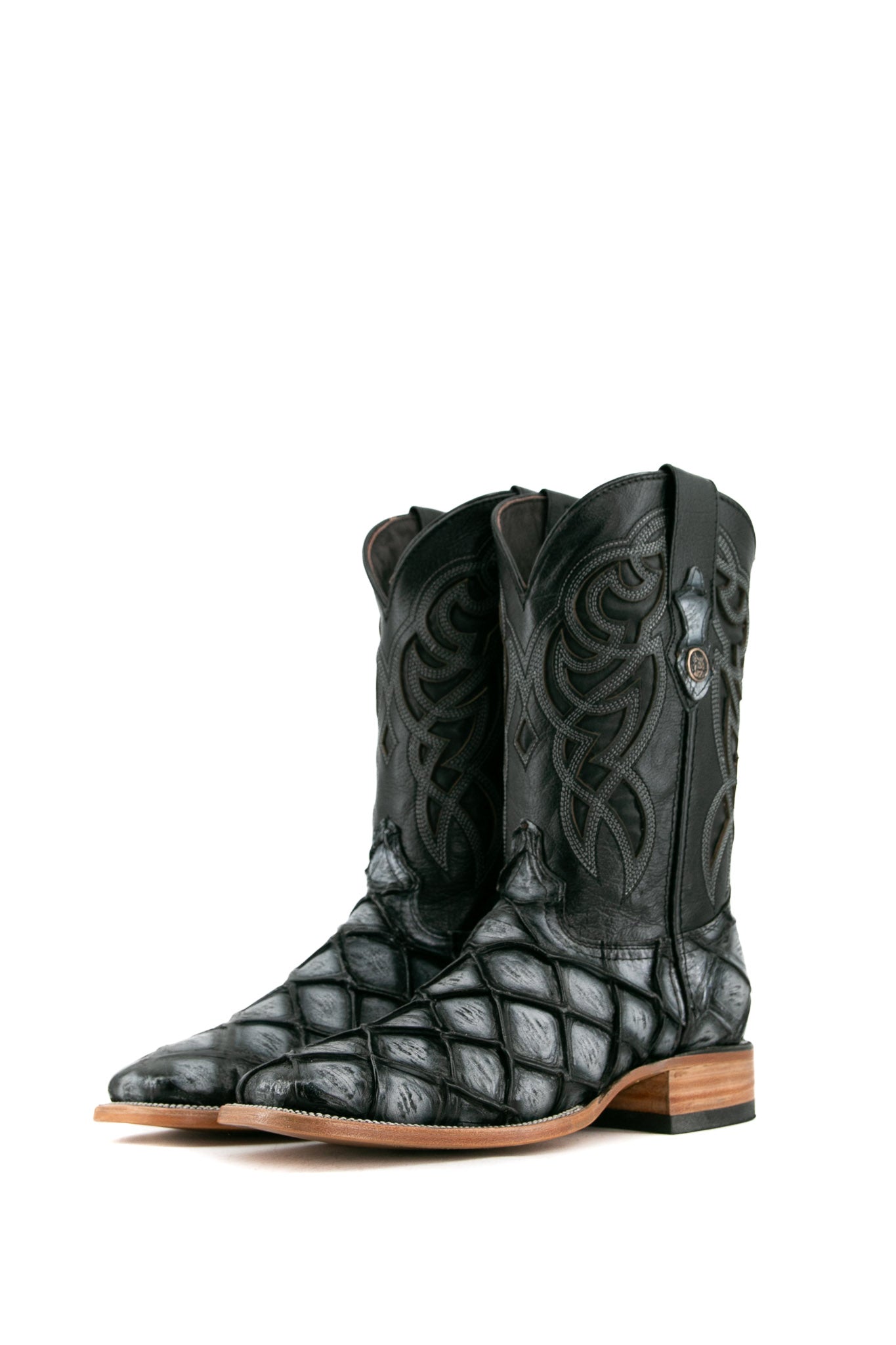 The black safari Big Bass Pirarucu Cowboy Boot features genuine leather, square toe, black and gray pirarucu print vamp, black embroidered shaft, rubber heel, and tan sole.