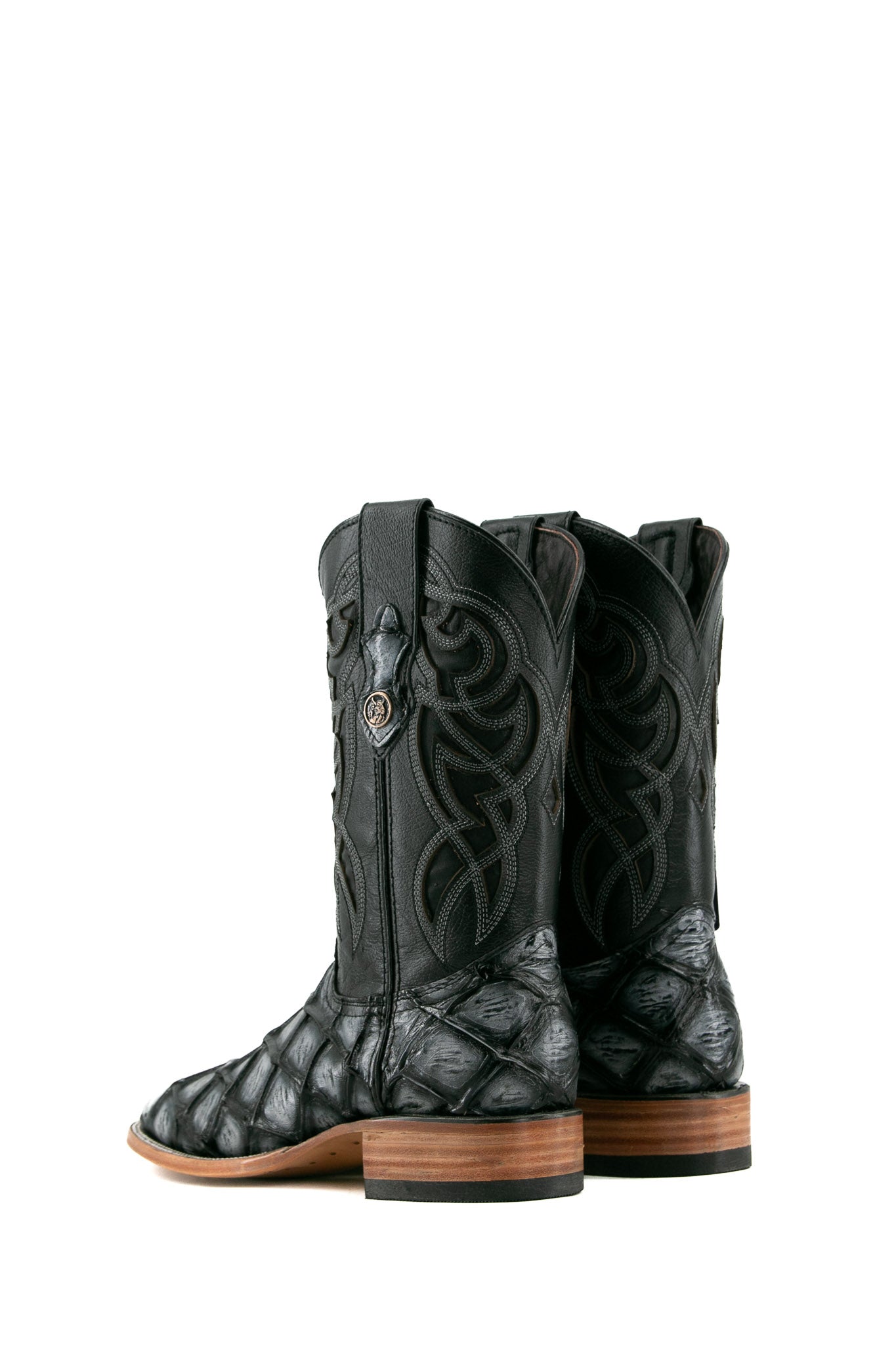 Back view of black safari Big Bass Pirarucu Cowboy Boot features genuine leather, square toe, black and gray pirarucu print vamp, black embroidered shaft, rubber heel, and tan sole.