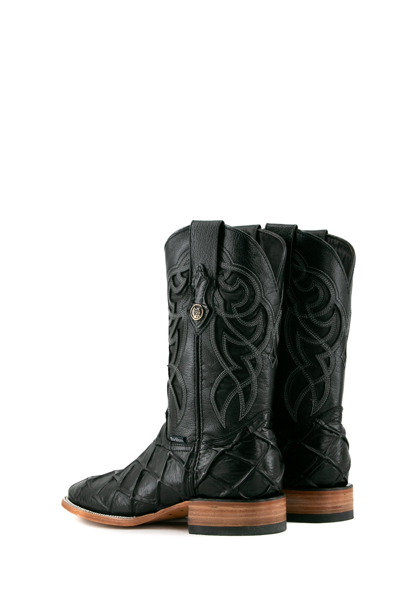 Back view of black Big Bass Pirarucu Cowboy Boot in genuine leather, square toe, black pirarucu print vamp, black embroidered shaft, rubber heel, and tan sole.
