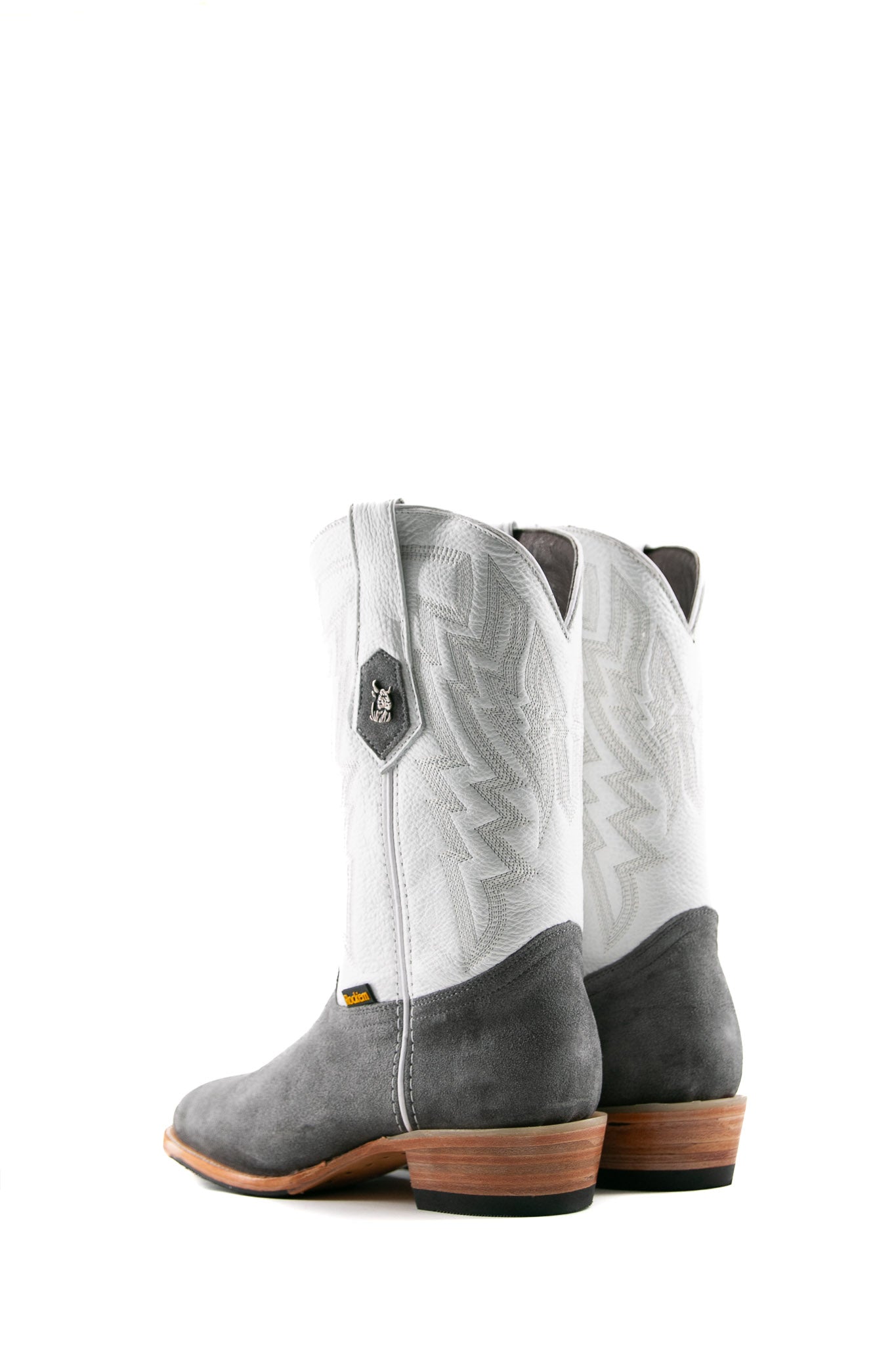 Back view of the Maverick boots feature a grey suede vamp, white shaft, square toe, sturdy leather sole, and rubber heel.
