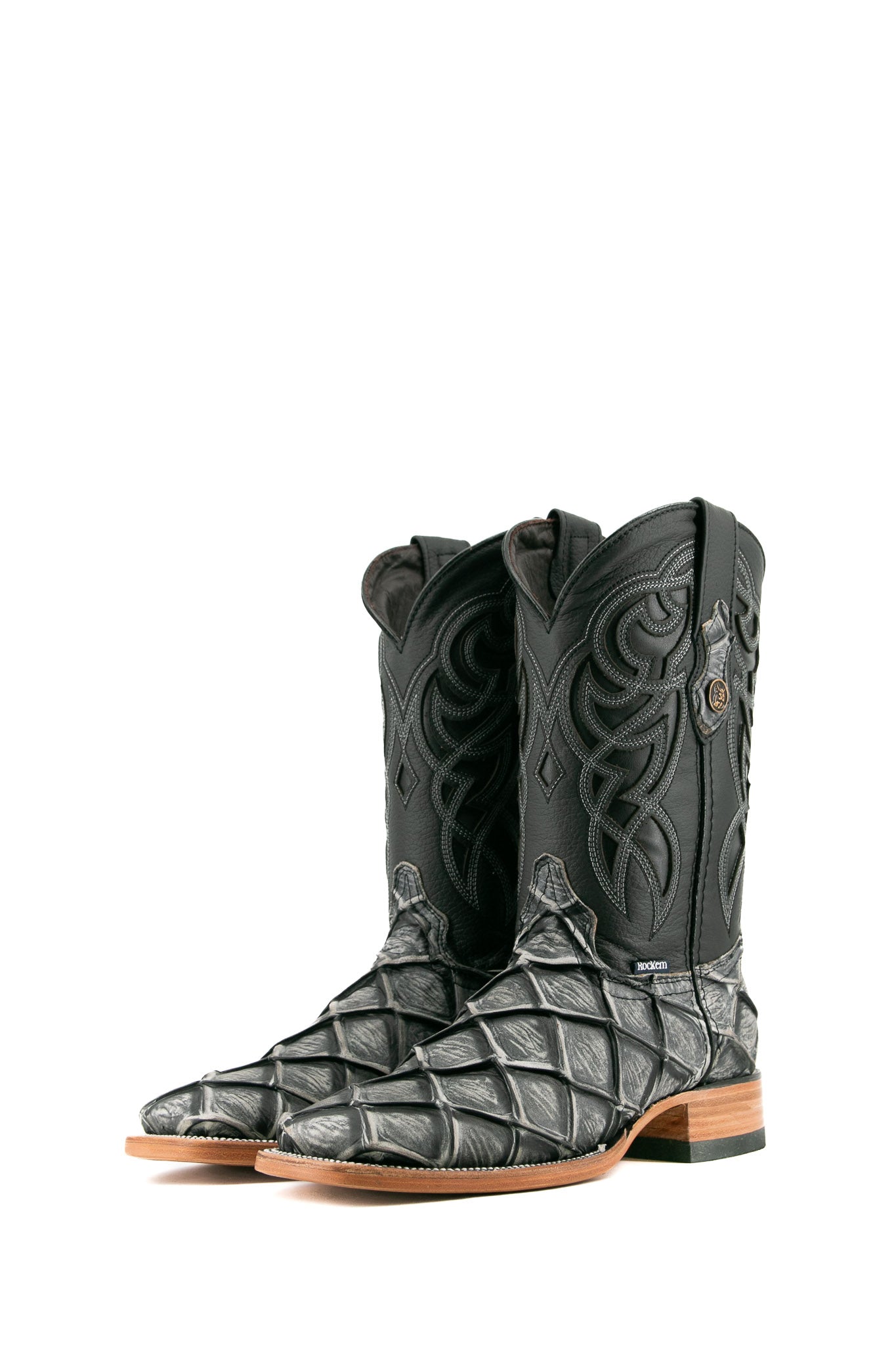 The granite safari Big Bass Pirarucu Cowboy Boot in genuine leather, square toe, gray pirarucu print vamp, black embroidered shaft, rubber heel, and tan sole.