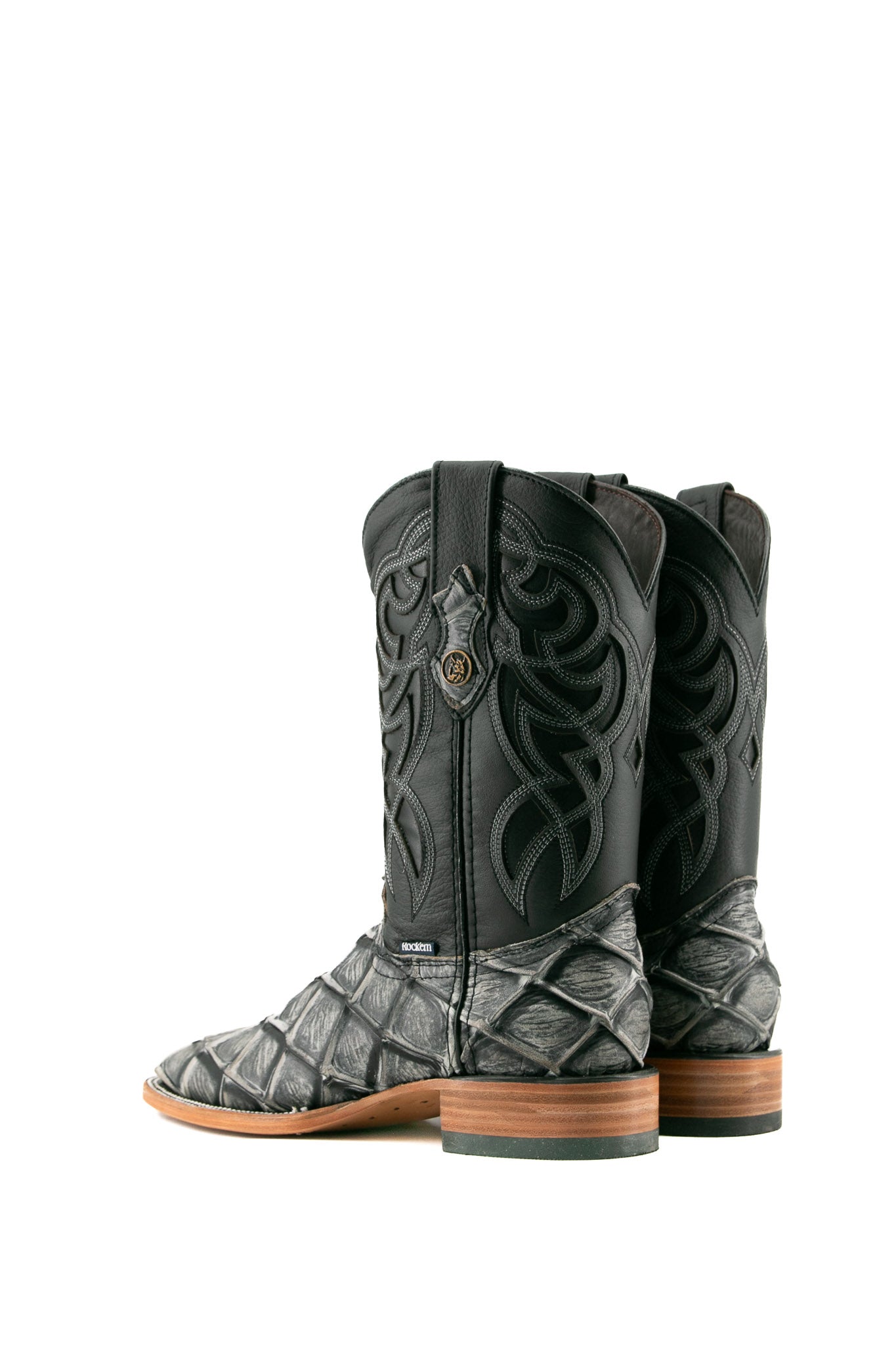 Back view of granite safari Big Bass Pirarucu Cowboy Boot in genuine leather, square toe, gray pirarucu print vamp, black embroidered shaft, rubber heel, and tan sole.