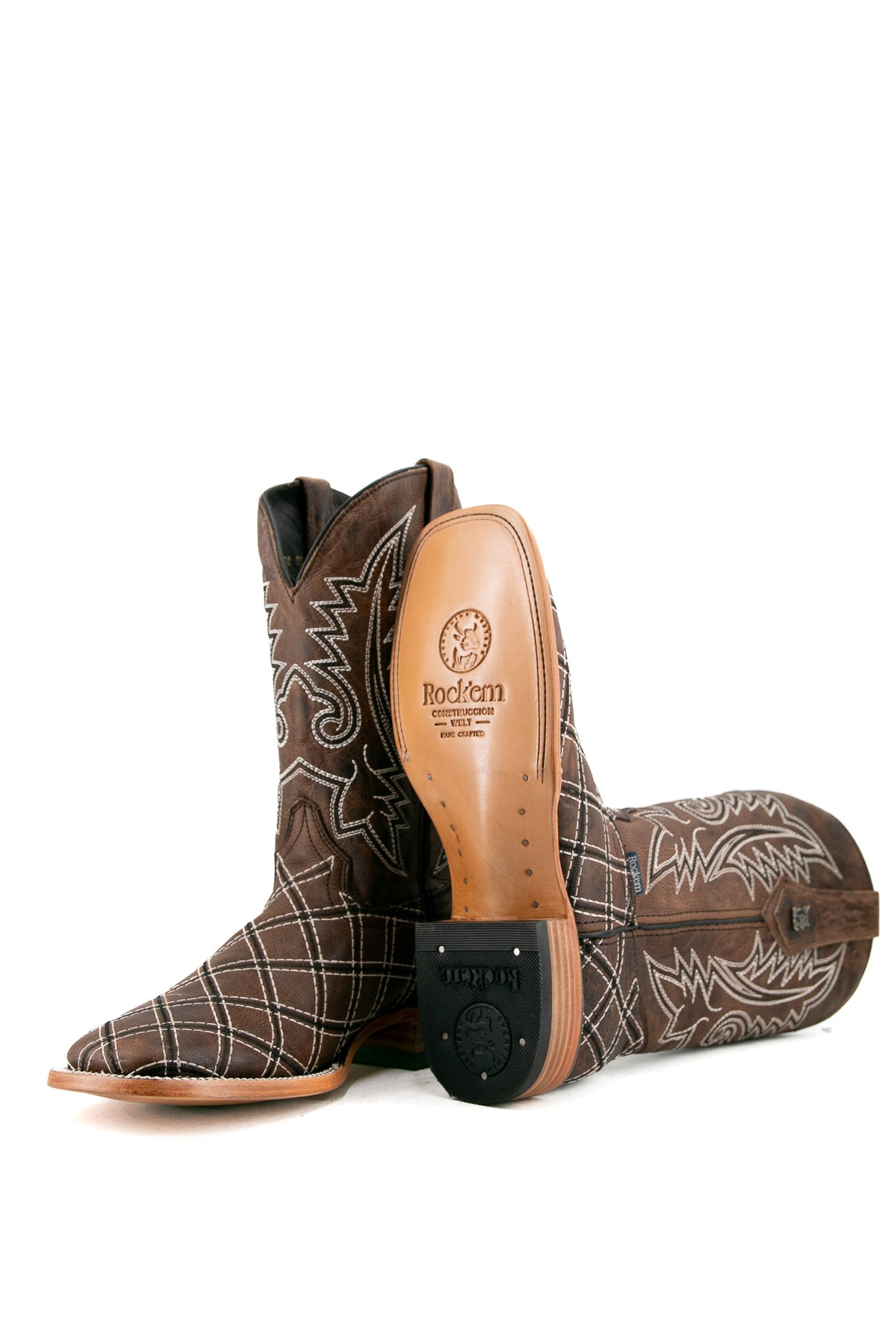 View of paja Roca Patchwork Cowboy Boot in genuine leather, square toe, brown roca patchwork print vamp, brown embroidered shaft, rubber heel, and tan sole.