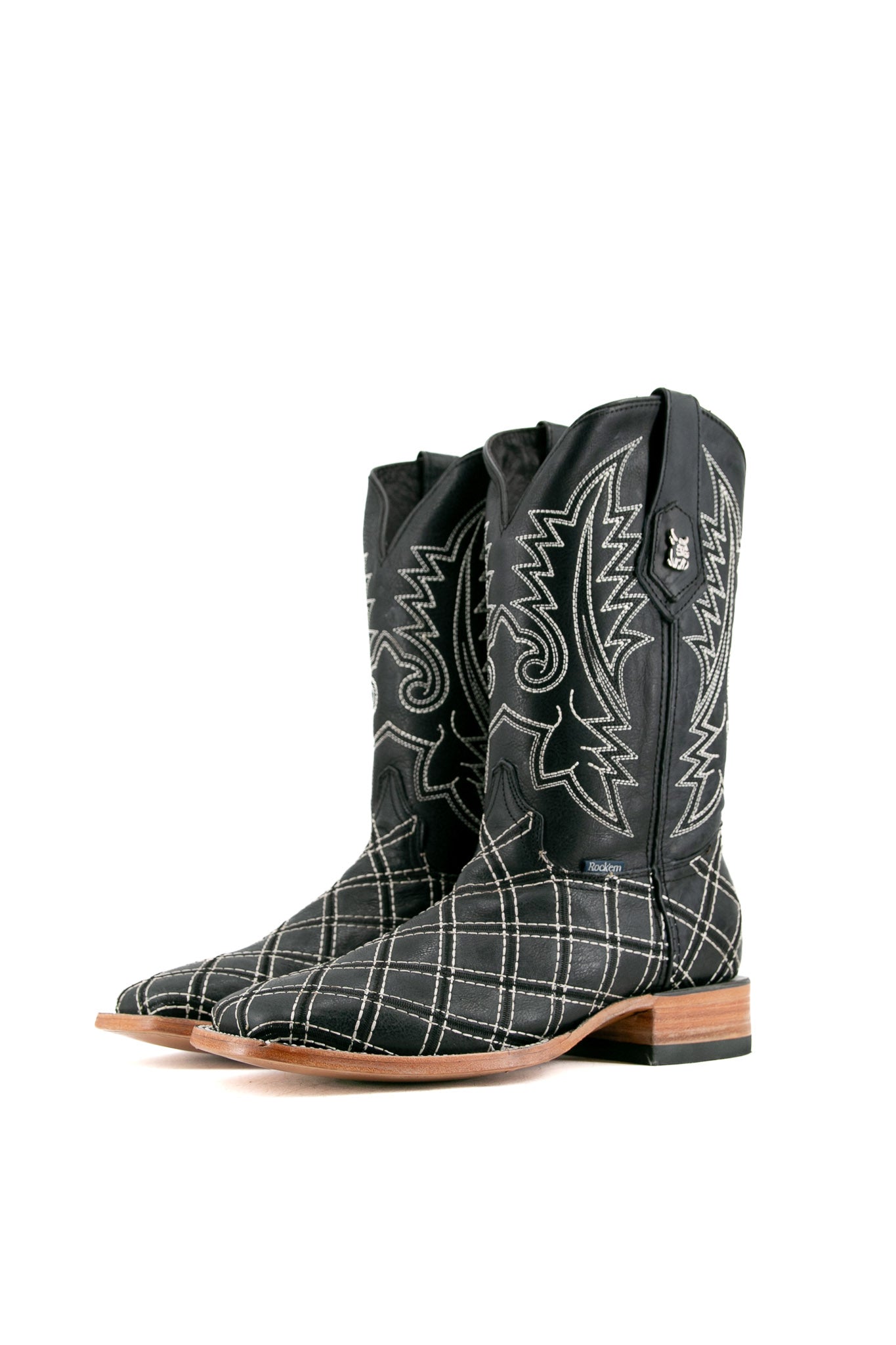 The negro Roca Patchwork Cowboy Boot in genuine leather, square toe, black roca patchwork print vamp, black embroidered shaft, rubber heel, and tan sole.