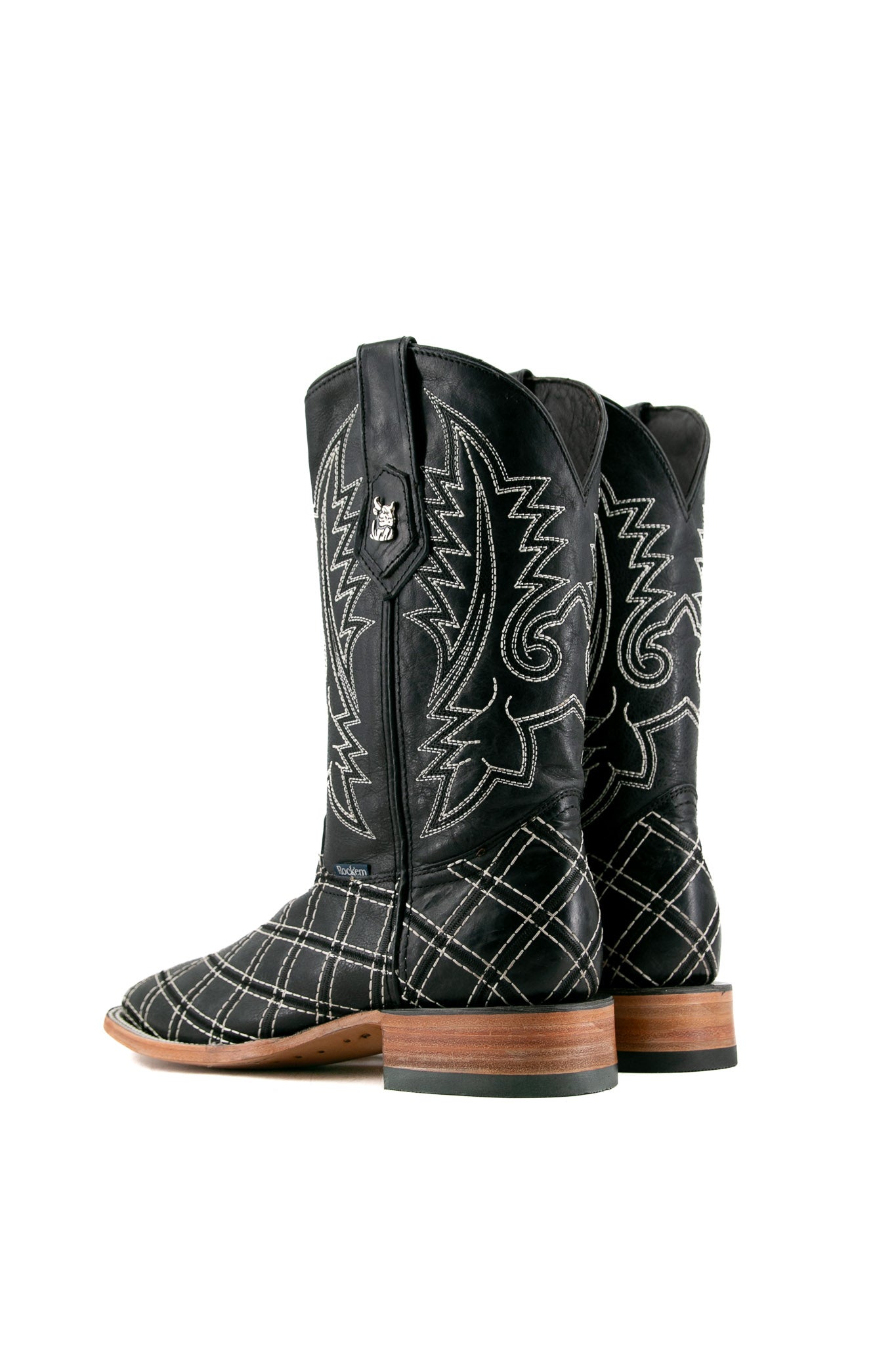 Back view of negro Roca Patchwork Cowboy Boot in genuine leather, square toe, negro roca patchwork print vamp, negro embroidered shaft, rubber heel, and tan sole.