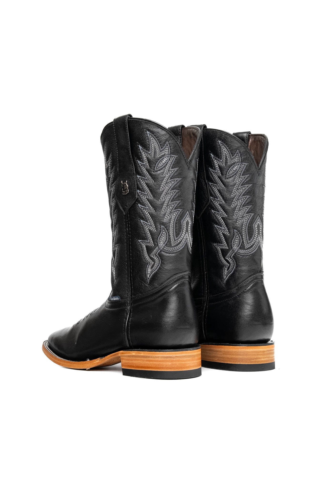 The Heritage Rainbow cowboy boots feature black leather with intricate stitching and embroidery, a Rock'em bull emblem, durable leather sole, and rubber heel.