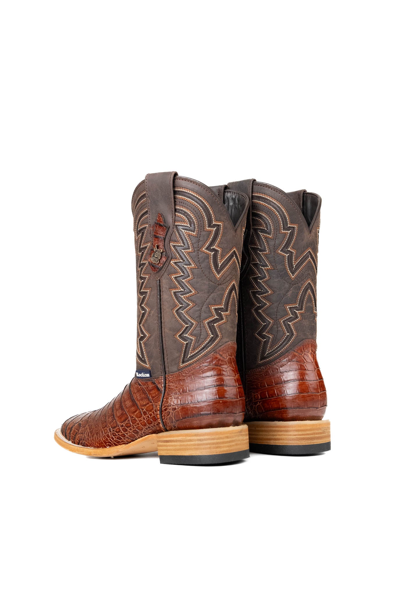 Back view of the Bruce Belly Caiman Cowboy Boots in cognac. Made of genuine leather with a round toe, cognac color belly caiman print vamp, brown embroidered shaft, and leather sole.