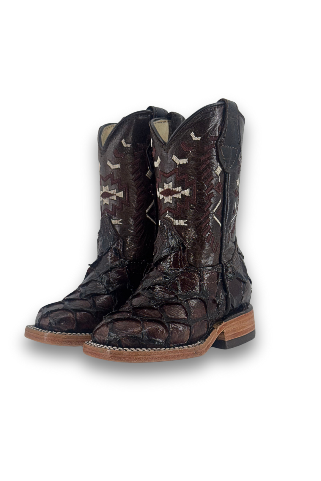 The Clone Fish Pirarucu Aztec Kids Boot comes in all brown, featuring a square toe, pirarucu vamp, embroider shaft, leather sole, and rubber heel.