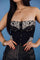 A black strapless suede bustier tube top featuring western-style embroidery with floral and arrow motifs, and a button-up front with metallic round decorative buttons.