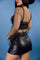Close-up view of the back of a vegan leather mini skort featuring side pockets, a sleek cut, and subtle detailing.