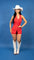 Full body picture of a woman wearing a red vest-style romper with silver buttons.