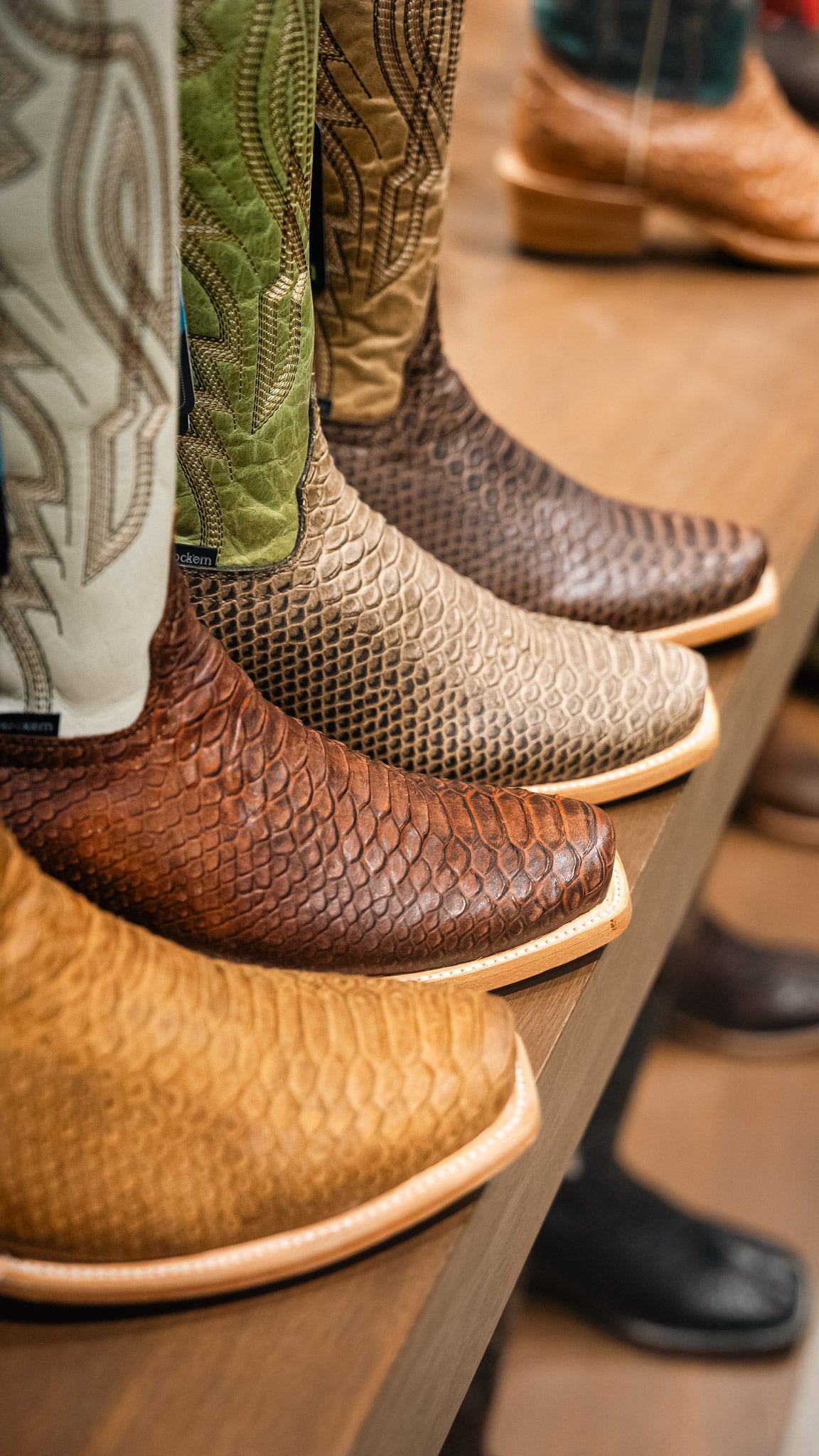 Close-up of various Rock'em boots on a wooden shelf