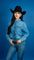 Close up view of a woman wearing a long sleeved denim shirt with pearl snaps.