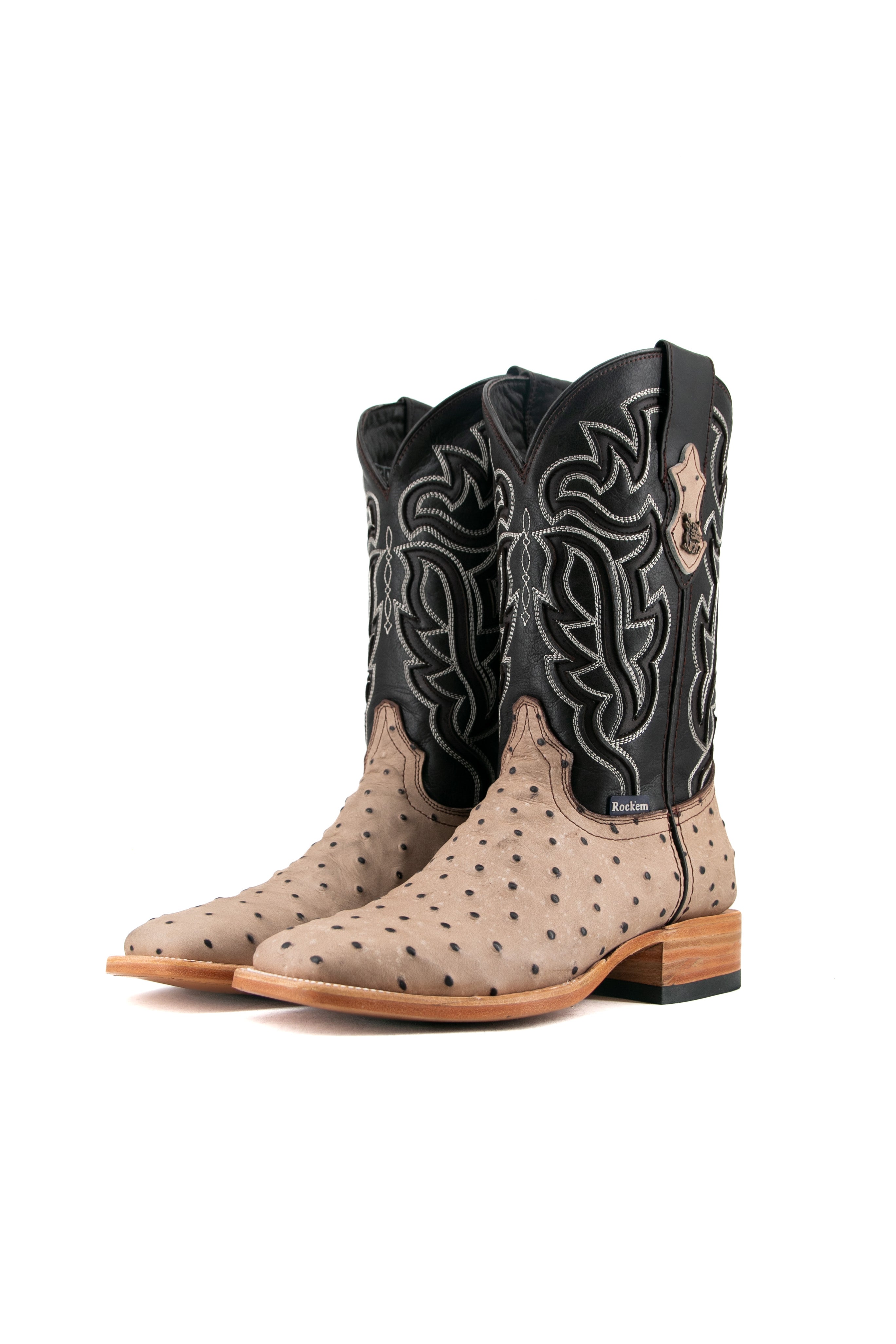 The Bruce Ostrich cowboy boot in Desert features a bumpy vamp, flame inlays on a dark shaft, square toe, leather sole, and rubber heel.