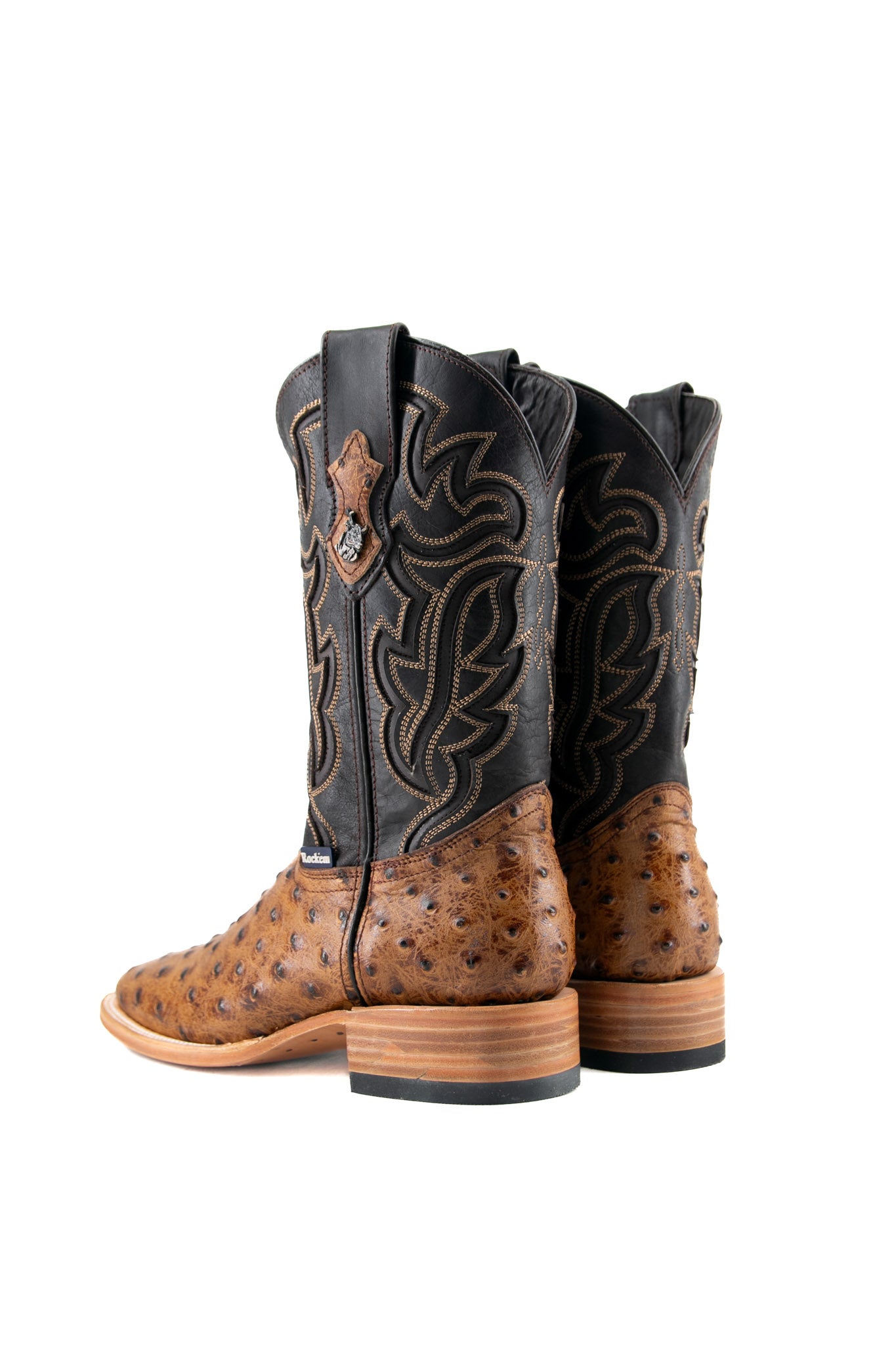 Back view of the Bruce ostrich cowboy boot in maple featuring a bumpy vamp, flame inlays on a dark shaft, square toe, leather sole, and rubber heel.