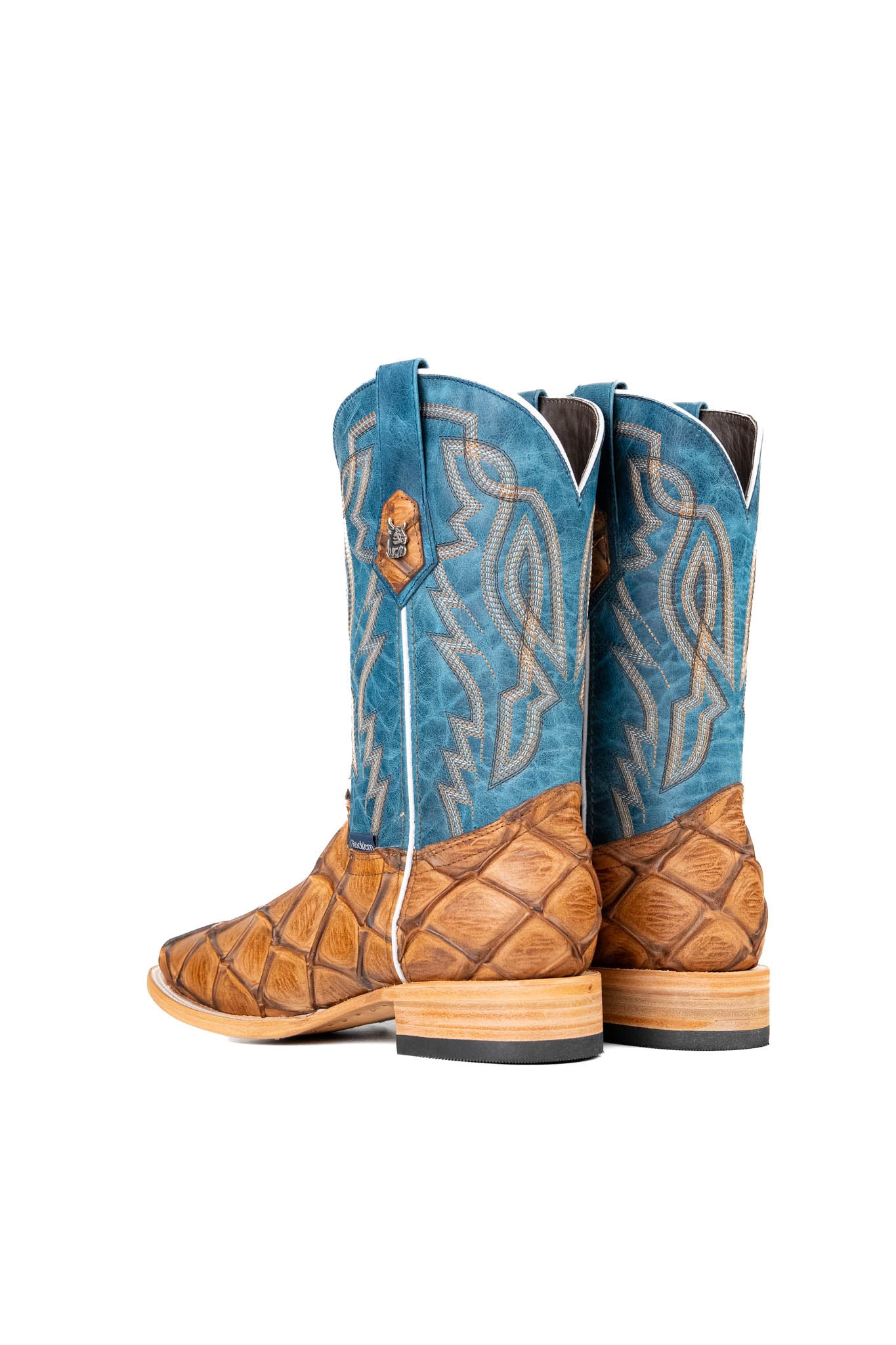 Back view of the Renegate Big Bass Pirarucu boot features a tan Pirarucu fish print vamp, a blue leather shaft with embroidery, a square toe, and leather sole. 
