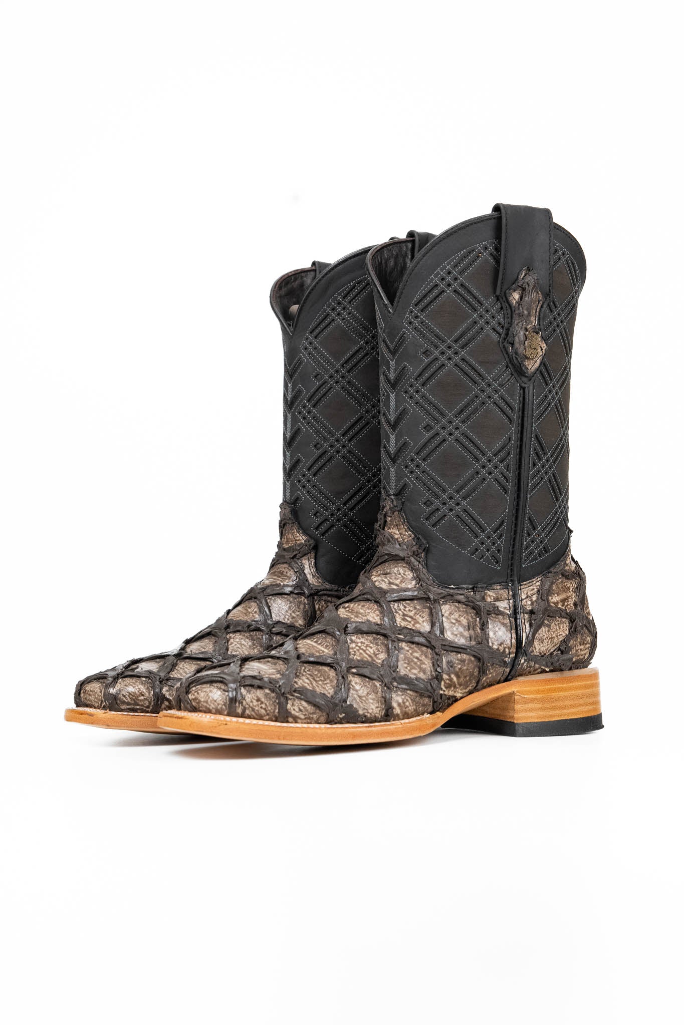 The Bradley boot features an old silver Pirarucu fish print vamp, a black leather shaft with a laser-cut pattern, a square toe, and a natural-tone sole.