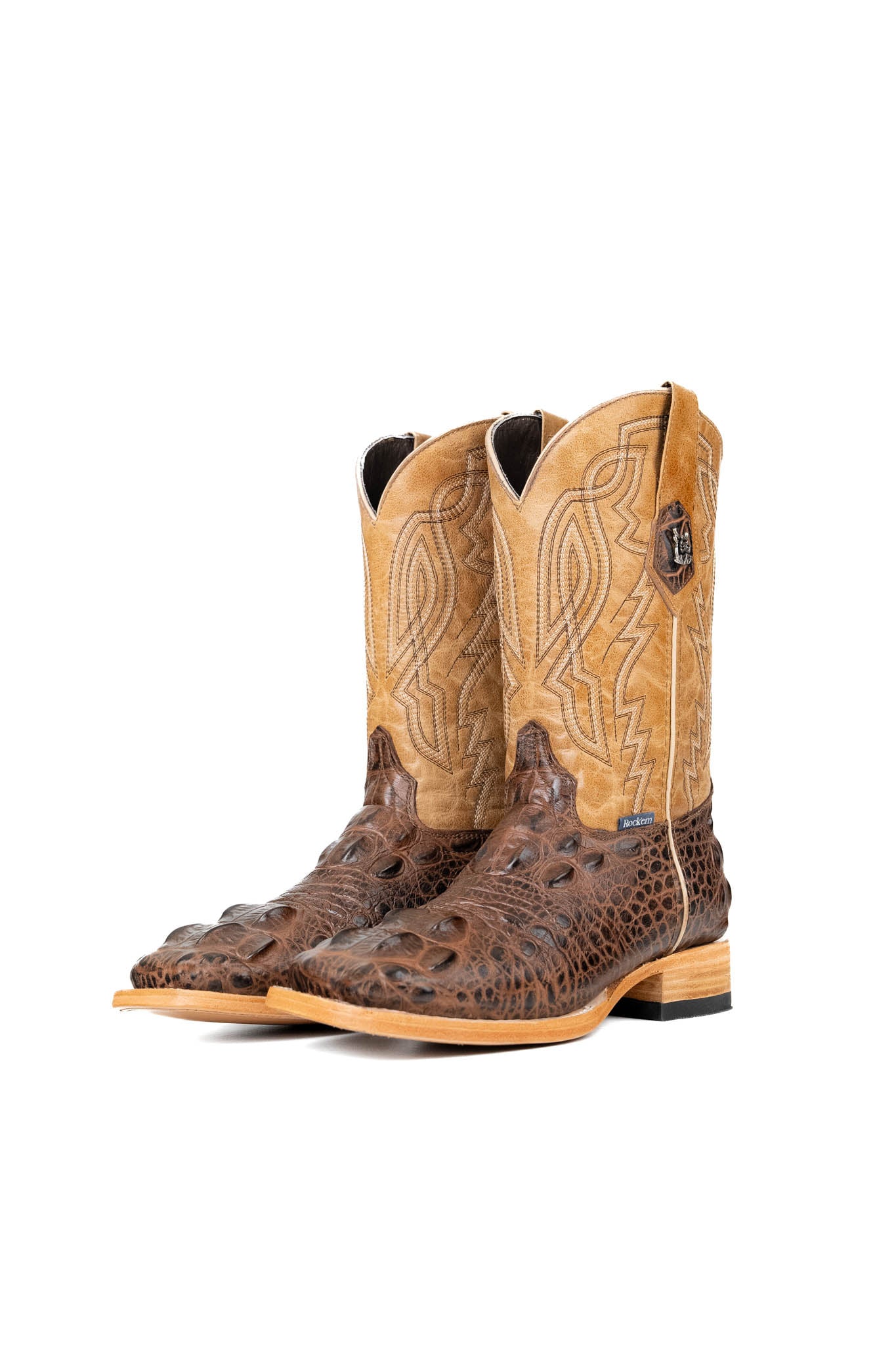 The Renegate Giant Alligator Cowboy Boot in brown made of genuine leather, featuring a square toe, brown caiman print vamp, tan shaft with embroidery, and rubber heel. 