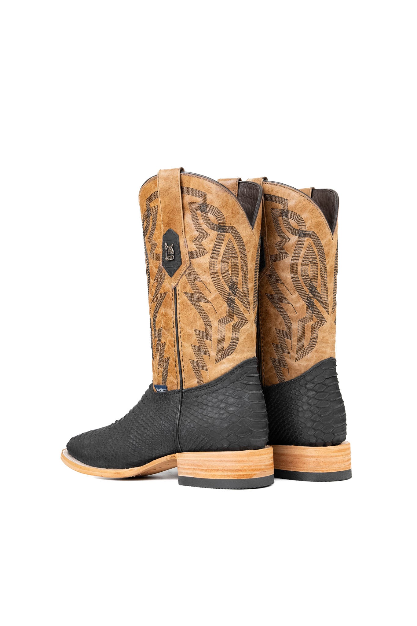 Back view of the Renegate Python boot in matte black featuring a  black Pirarucu fish print vamp, tan leather shaft with embroidery, a square toe, and leather sole. 
