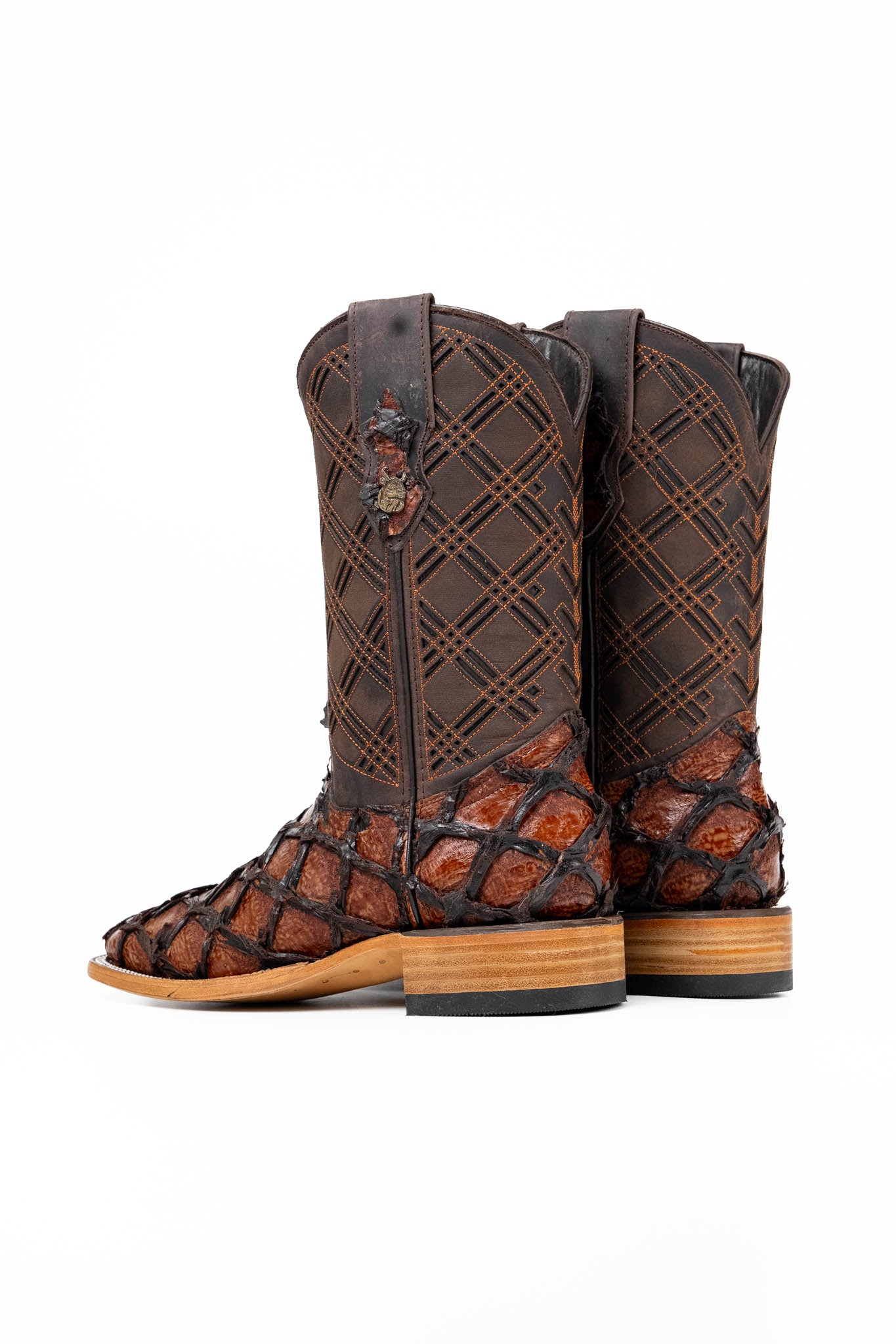 The Bradley boot features a cognac Pirarucu fish print vamp, a brown leather shaft with a laser-cut pattern, a square toe, and a natural-tone sole.