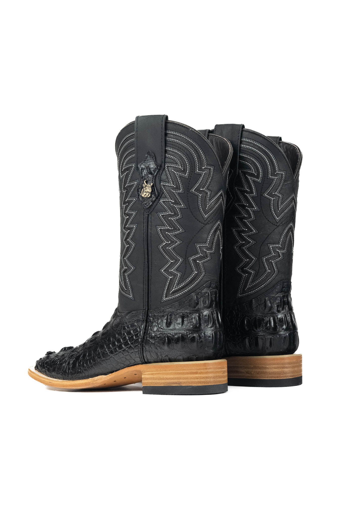 The Jameson boots have a black caiman-textured vamp, a black shaft with bold zigzag stitching, a square toe, and a sturdy leather sole with a rubber heel.