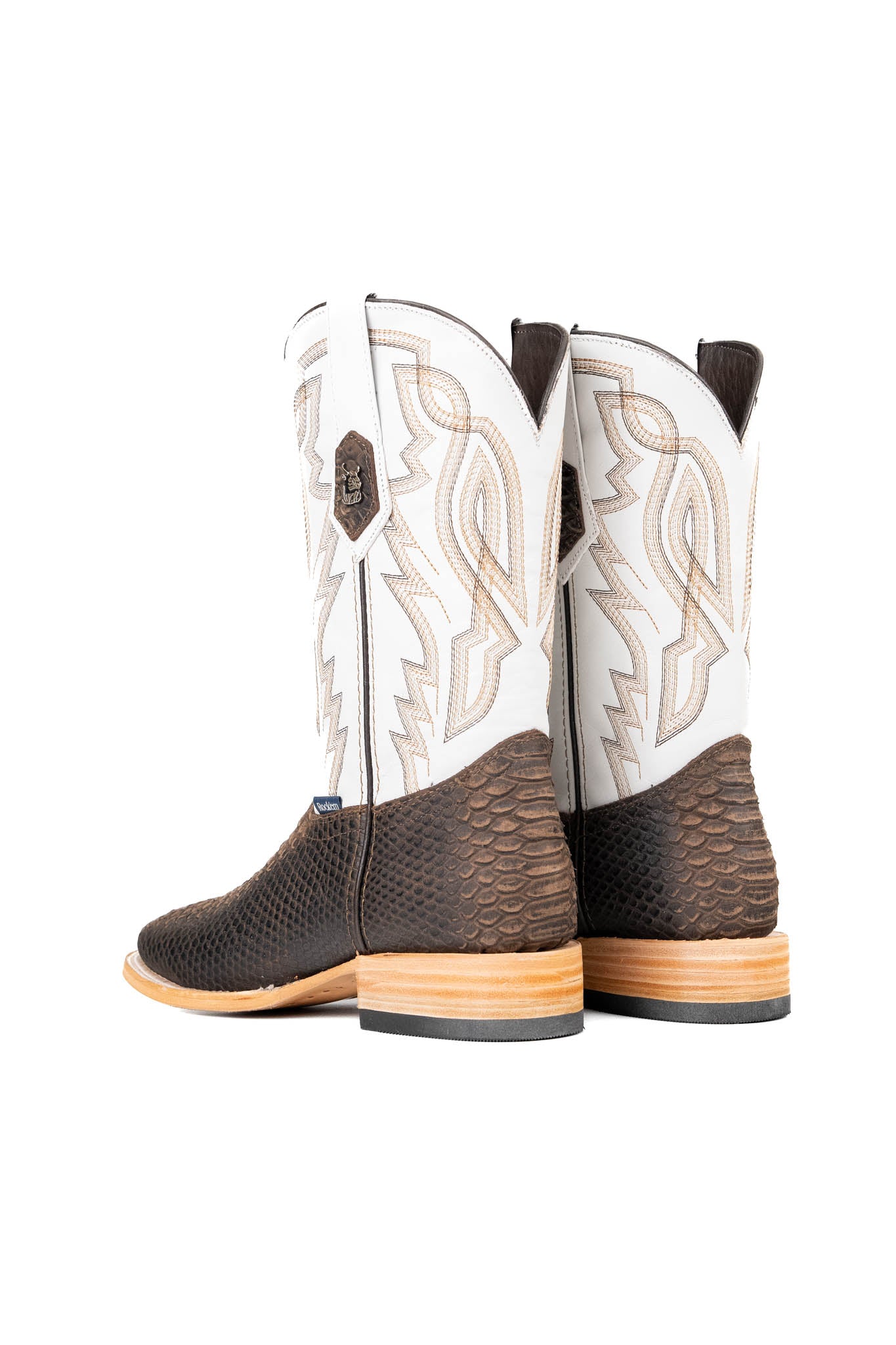 Back view of the Renegate Python boot in rustic brown featuring a brown pirarucu fish print vamp, white leather shaft with embroidery, a square toe, and leather sole. 