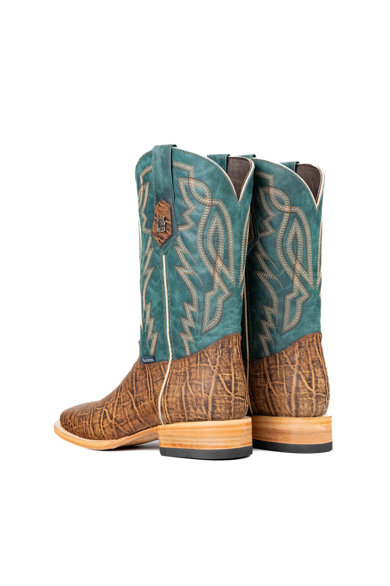 Back view of the Renegate Elephant cowboy boots crafted from genuine leather, featuring a square toe, brown elephant print vamp, teal shaft with embroidered shaft, and rubber heel.
