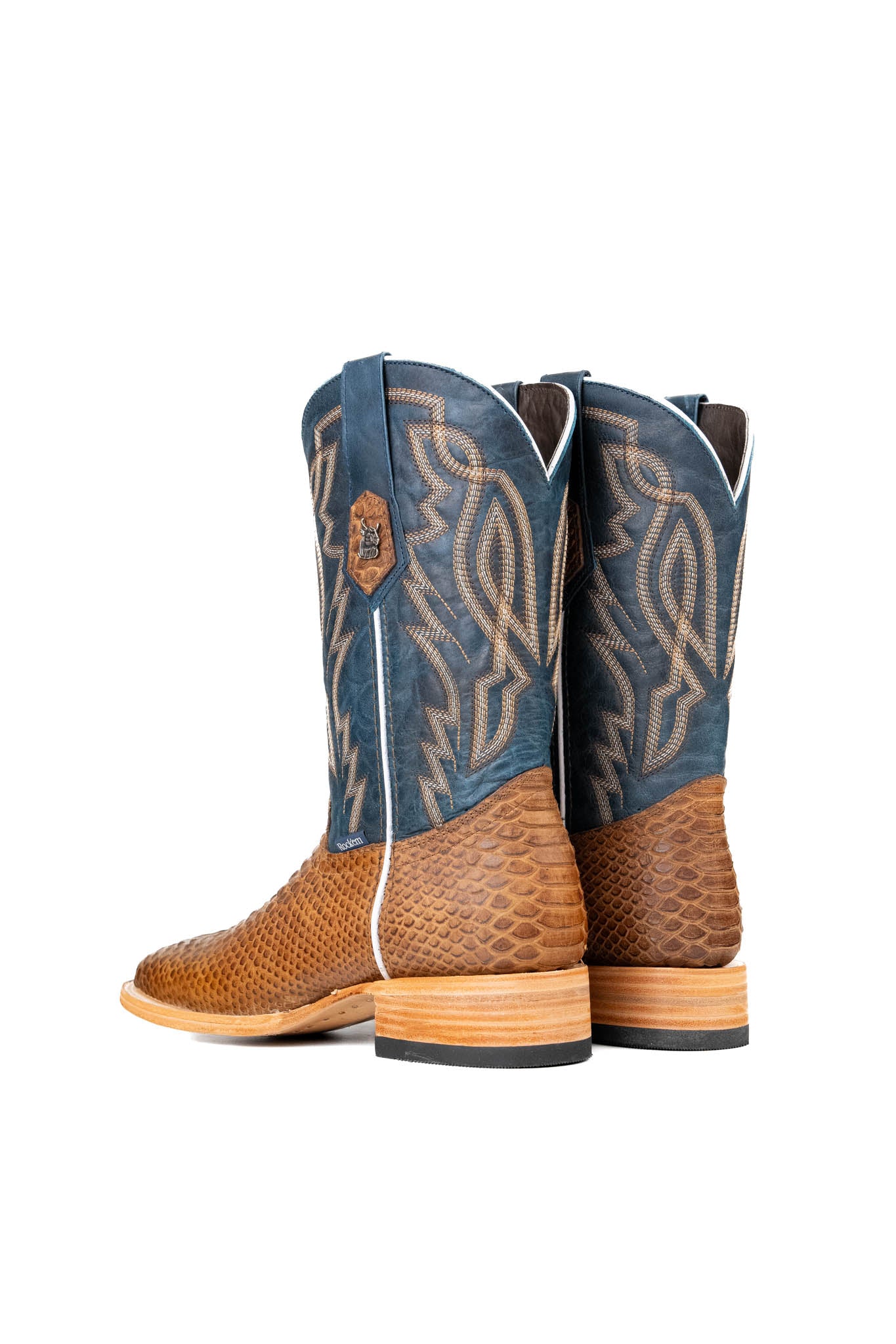 Back view of the Renegate Python boot in mapple featuring a tan pirarucu fish print vamp, blue leather shaft with embroidery, a square toe, and leather sole. 