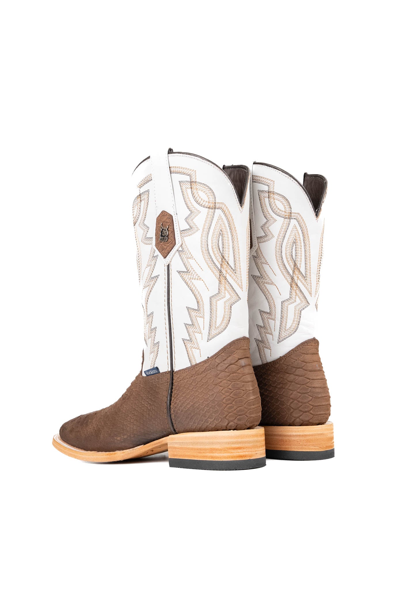 Back view of the Renegate Python boot in chocolate featuring a brown pirarucu fish print vamp, white leather shaft with embroidery, a square toe, and leather sole. 
