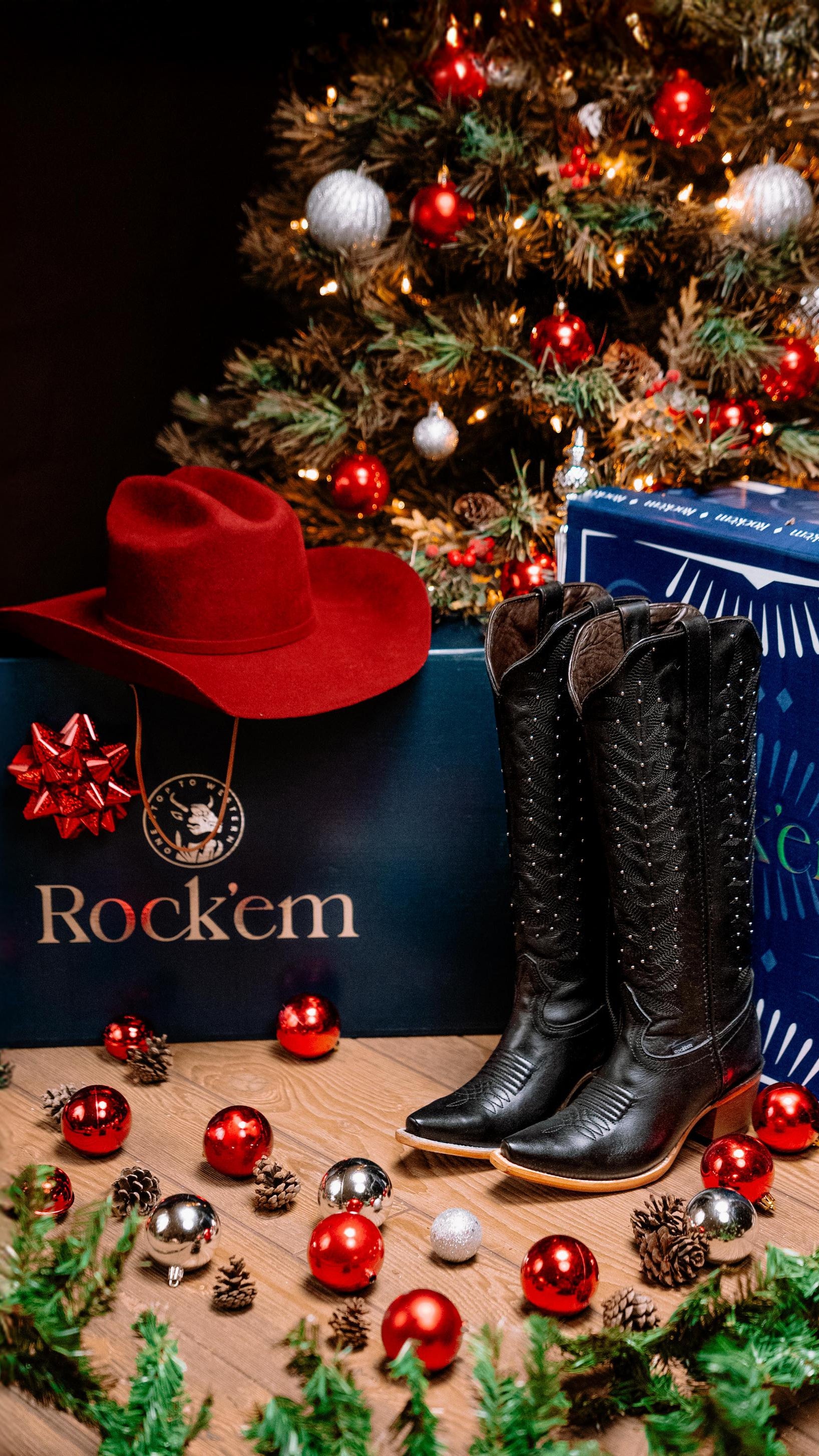 Christmas tree with decorative lights, boots, and 'Rock'em' branded boxes on a wooden surface.